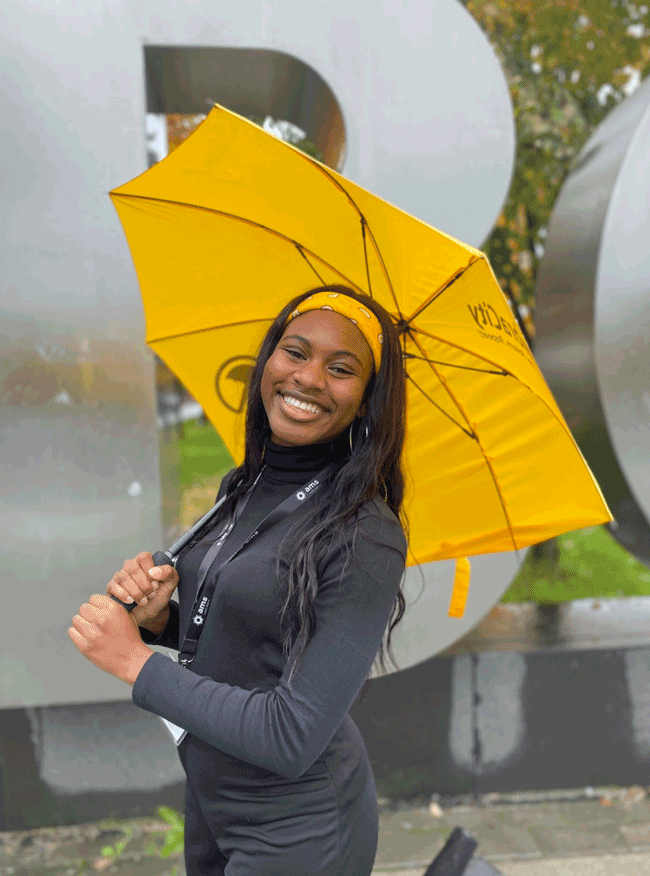 Picture of smiling woman holding yellow umbrella