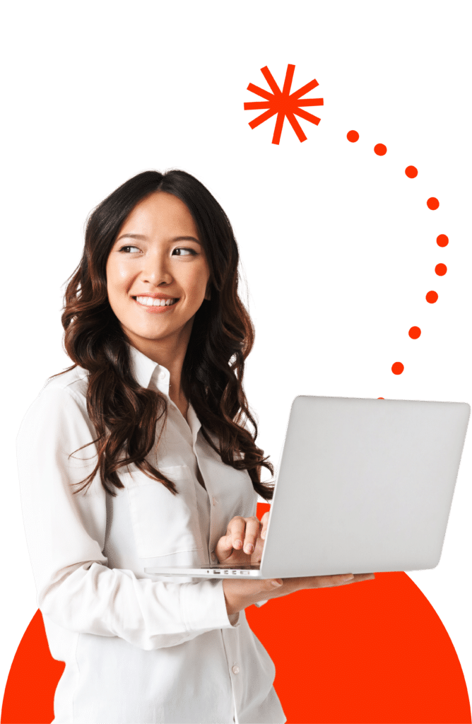 Woman standing and looking behind smiling, while holding her laptop with orange graphics in the background.