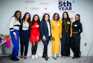 Team of 7 women standing together smiling and posing for the camera